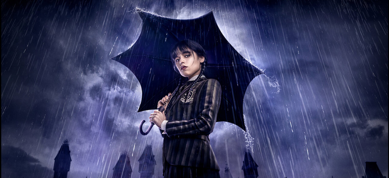 Jenna Ortega as Wednesday Addams holding an umbrella in the rain, from Netflix’s Wednesday series filmed using virtual production at Ashford Studios.